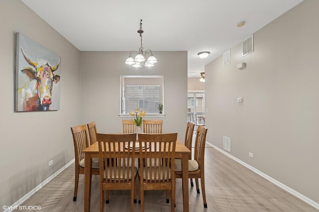 dining room with light wood-type flooring, visible vents, and baseboards