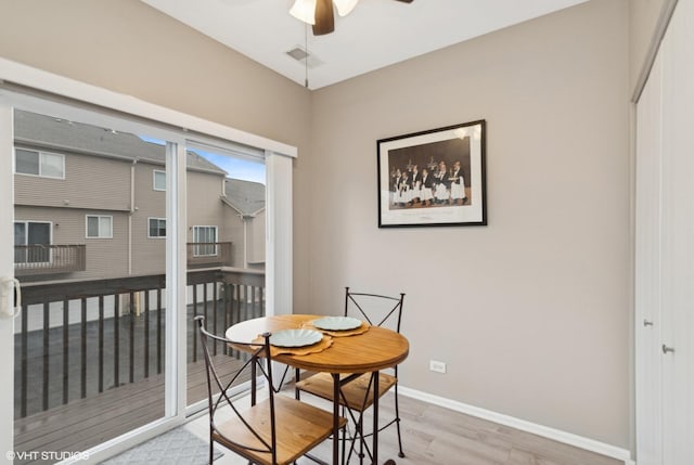 dining room featuring light wood-style flooring, visible vents, baseboards, and a ceiling fan