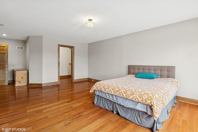 bedroom featuring visible vents, baseboards, and wood finished floors