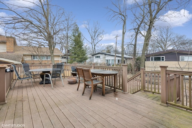 wooden terrace featuring a fire pit, outdoor dining area, and a residential view