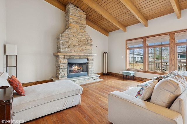 bedroom with wooden ceiling, baseboards, wood finished floors, and a stone fireplace