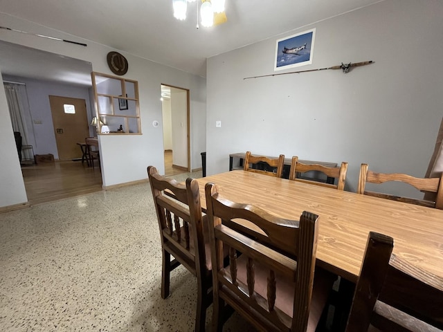 dining space with speckled floor and baseboards