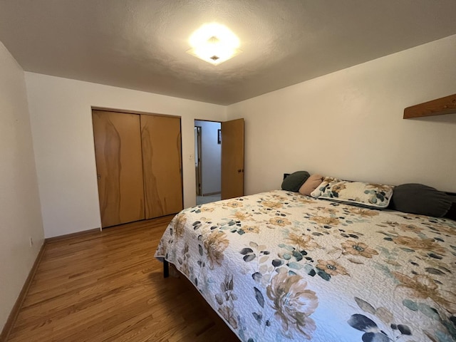 bedroom featuring a closet, baseboards, and wood finished floors