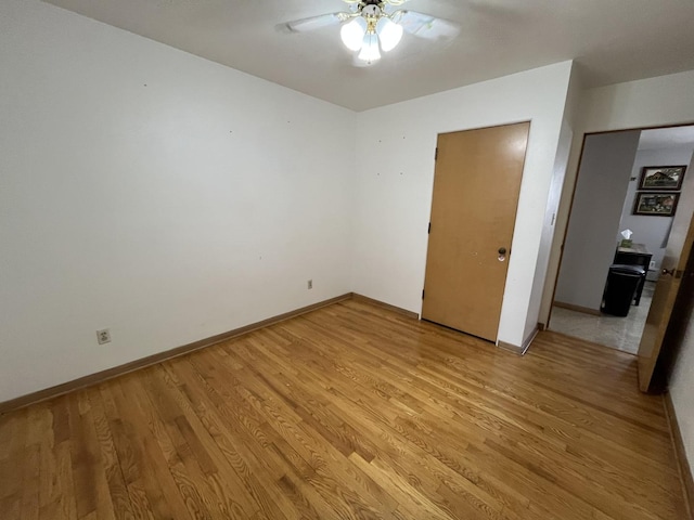 unfurnished bedroom with light wood-type flooring, ceiling fan, and baseboards