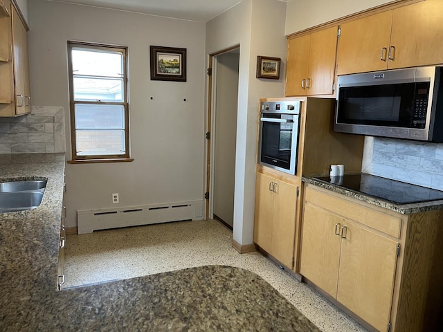 kitchen with a baseboard heating unit, stainless steel appliances, tasteful backsplash, and a sink