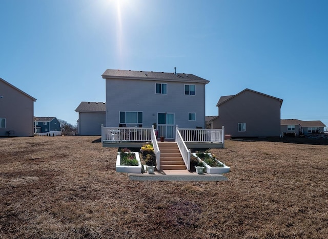 back of property featuring a lawn and a wooden deck