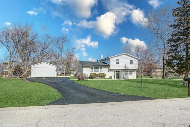 split level home with an outbuilding, a front lawn, and a detached garage