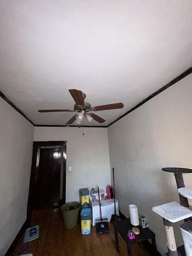 living area with ceiling fan, crown molding, and wood finished floors