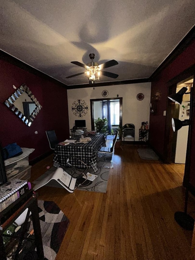 dining room with hardwood / wood-style flooring, a textured ceiling, ornamental molding, and a ceiling fan