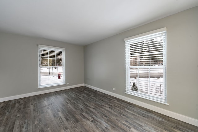 empty room with baseboards and dark wood finished floors