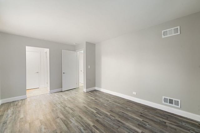 unfurnished bedroom with baseboards, visible vents, and wood finished floors