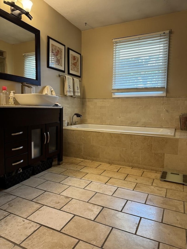 bathroom with vanity, a garden tub, and tile patterned floors