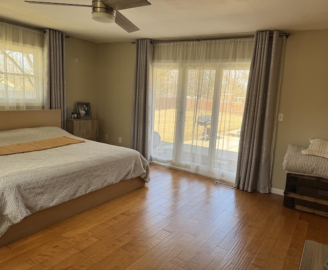 bedroom with access to outside, wood finished floors, and ceiling fan