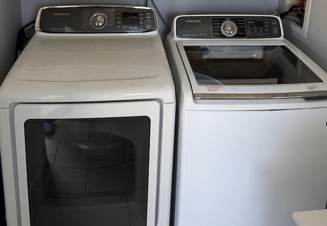 clothes washing area with independent washer and dryer and laundry area