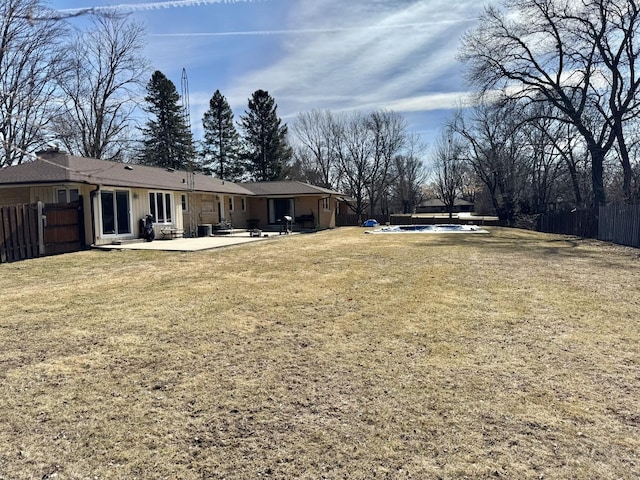 view of yard with a patio area, fence, and an outdoor pool