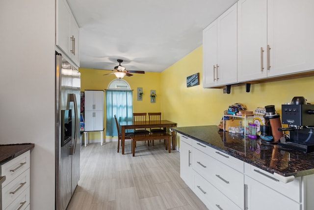 kitchen featuring ceiling fan, dark stone counters, white cabinets, and stainless steel fridge with ice dispenser