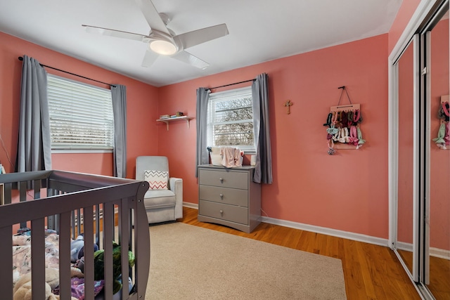 bedroom with a closet, ceiling fan, baseboards, and wood finished floors