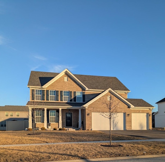 view of front of house featuring brick siding, driveway, a garage, and fence