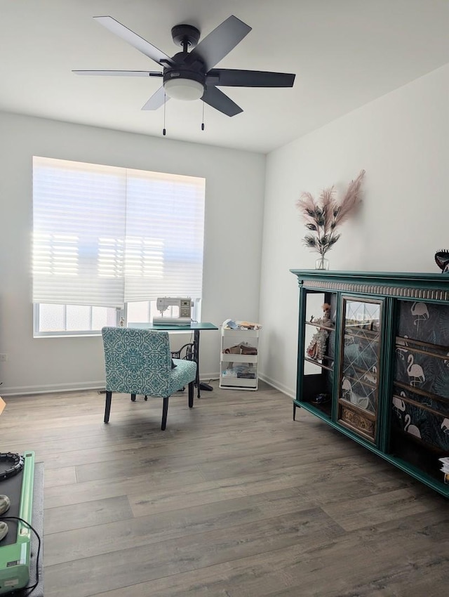 living area with baseboards and wood finished floors