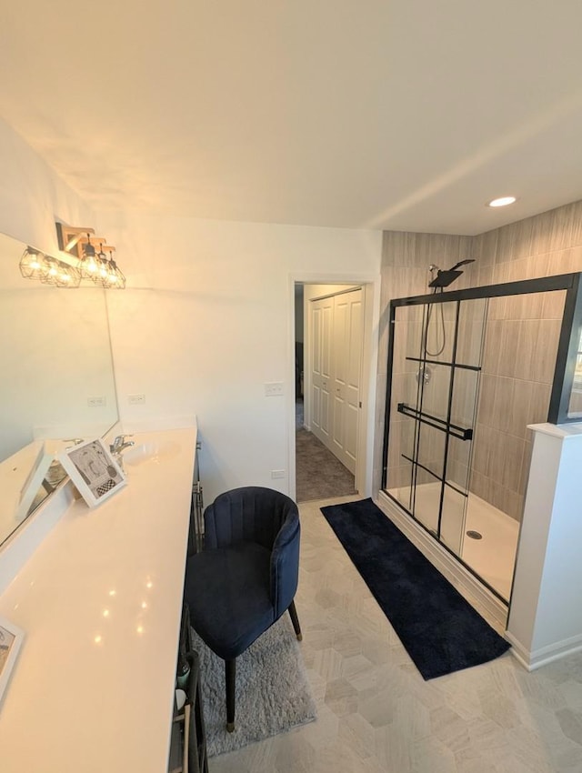 bathroom featuring tiled shower and vanity