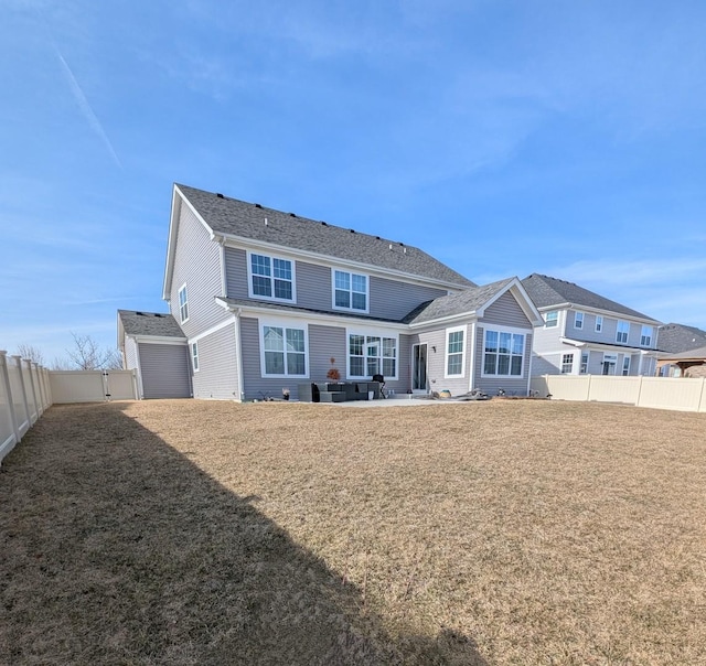 rear view of property featuring a lawn and a fenced backyard