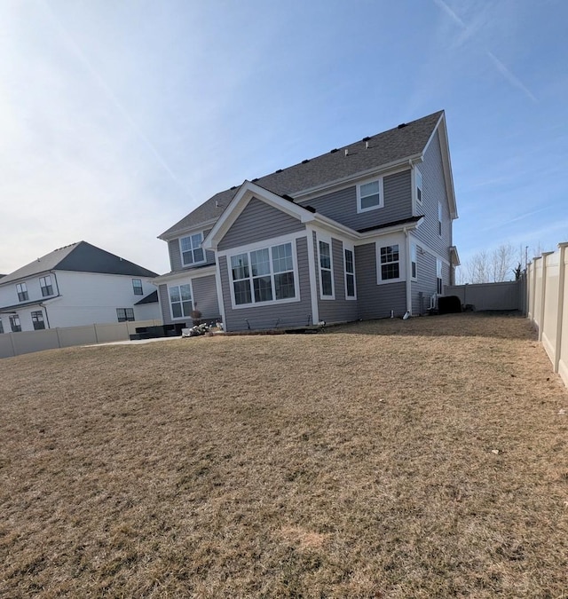 back of house featuring a lawn and a fenced backyard