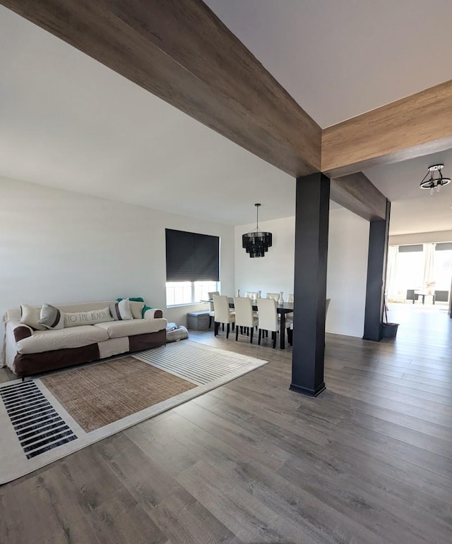 unfurnished living room with a notable chandelier and wood finished floors