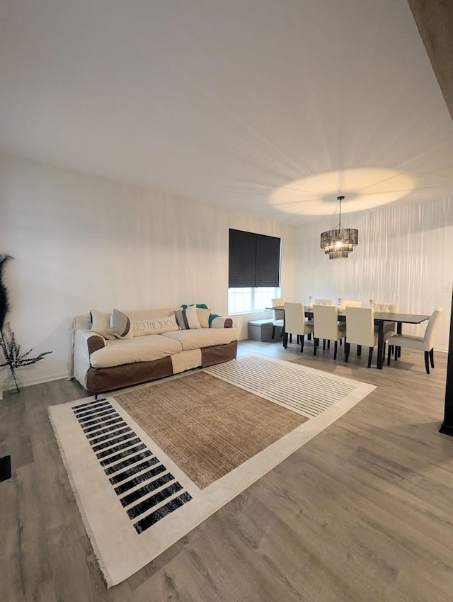 living area featuring a notable chandelier and wood finished floors