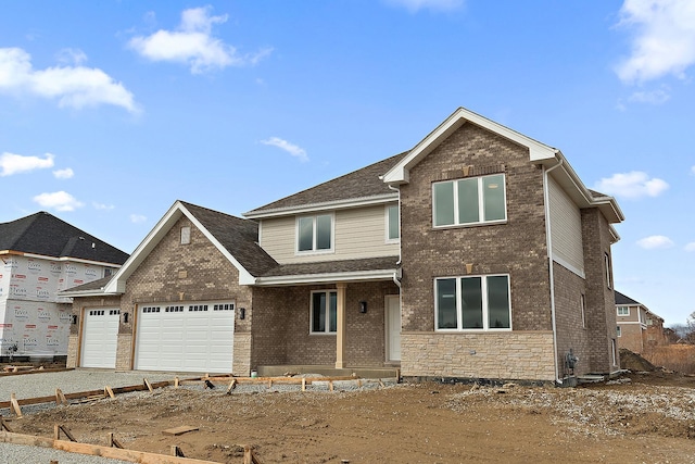 traditional-style home with stone siding, brick siding, and an attached garage