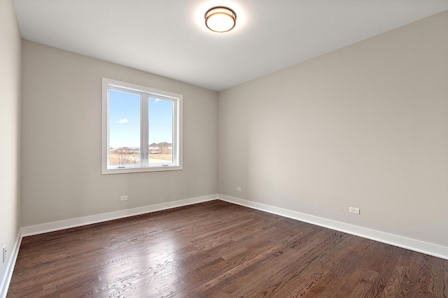 empty room with dark wood-style floors and baseboards