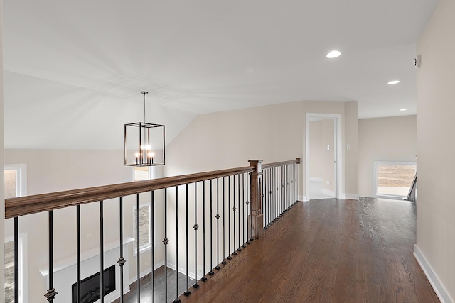 corridor featuring a chandelier, recessed lighting, dark wood-style flooring, baseboards, and vaulted ceiling