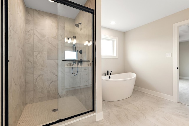 full bathroom with a stall shower, baseboards, marble finish floor, and a freestanding tub