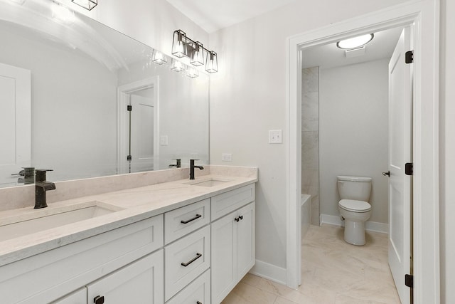 bathroom featuring baseboards, a sink, toilet, and double vanity