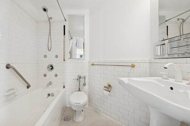 full bathroom featuring tile walls, toilet, tub / shower combination, a sink, and tile patterned flooring