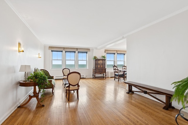 living area featuring light wood-type flooring, baseboards, baseboard heating, and crown molding