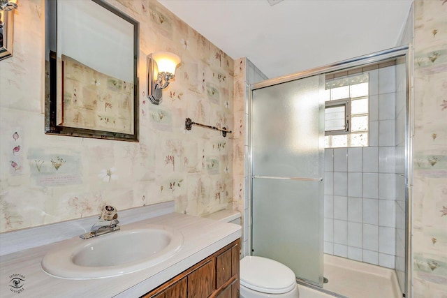 full bath featuring a stall shower, vanity, toilet, and wallpapered walls