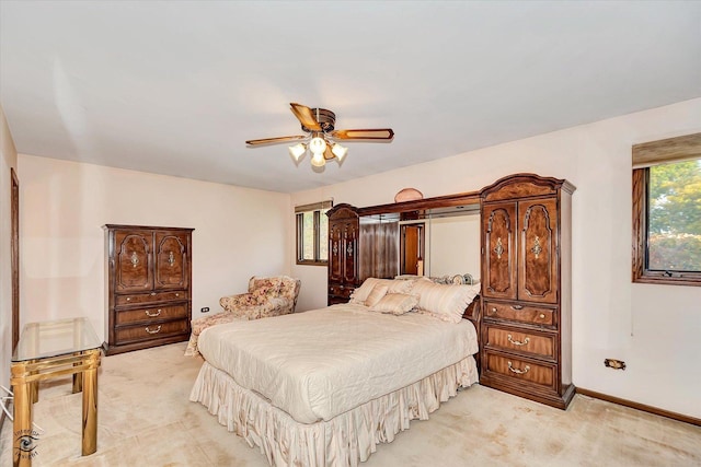 bedroom with baseboards, a ceiling fan, and light colored carpet