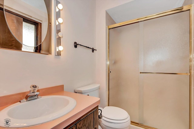 bathroom with vanity, a shower stall, and toilet