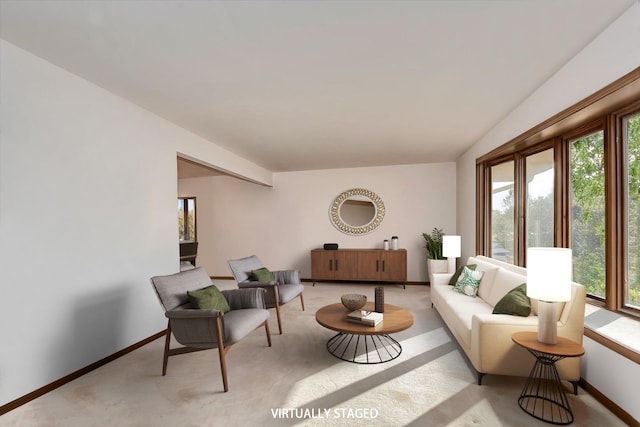 living area with baseboards and light colored carpet