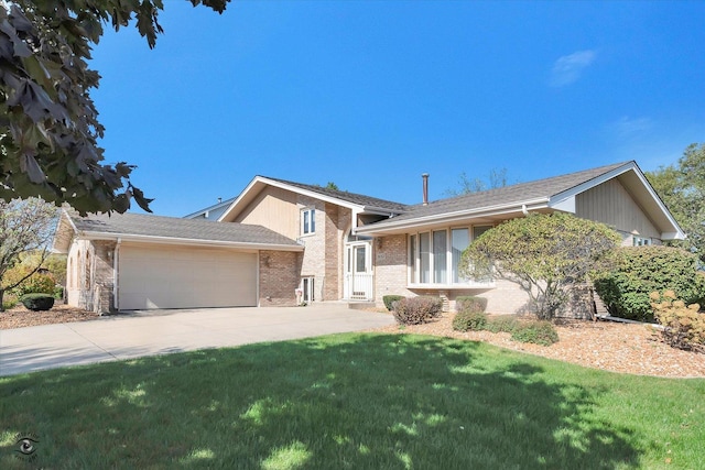 split level home with a garage, concrete driveway, brick siding, and a front yard