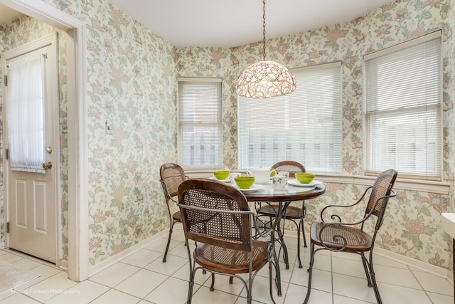 dining room with light tile patterned floors, baseboards, and wallpapered walls