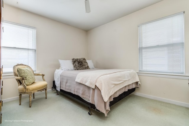 bedroom with light carpet, a ceiling fan, and baseboards