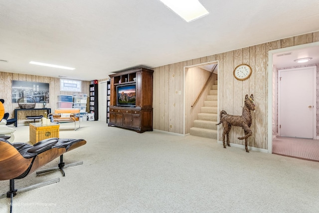 living room with wood walls, stairway, and carpet