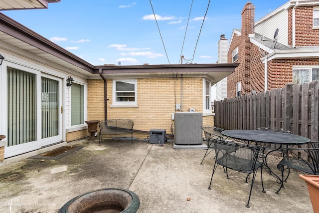 view of patio / terrace with outdoor dining area, fence, and central AC unit