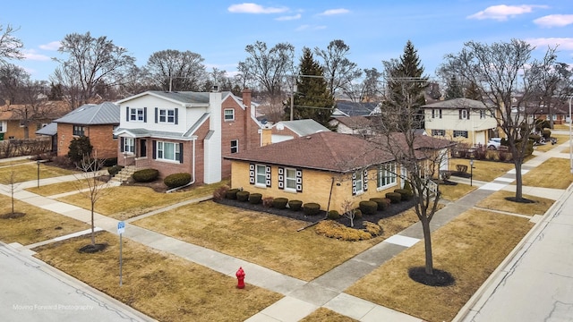 traditional home featuring brick siding, a residential view, and a front yard