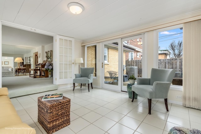 living area with french doors, light tile patterned flooring, and baseboards