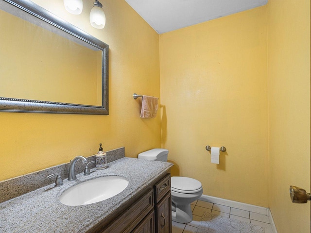 bathroom featuring tile patterned flooring, toilet, vanity, and baseboards