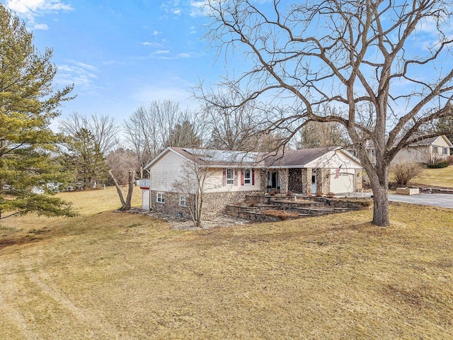 view of front of house featuring a front lawn, an attached garage, and driveway