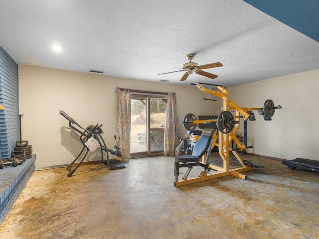 exercise room featuring visible vents, a textured ceiling, and a ceiling fan