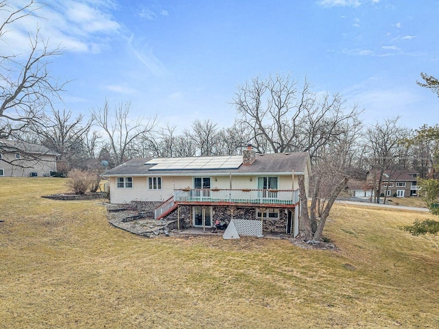 back of house with stairway, a lawn, a deck, and a chimney